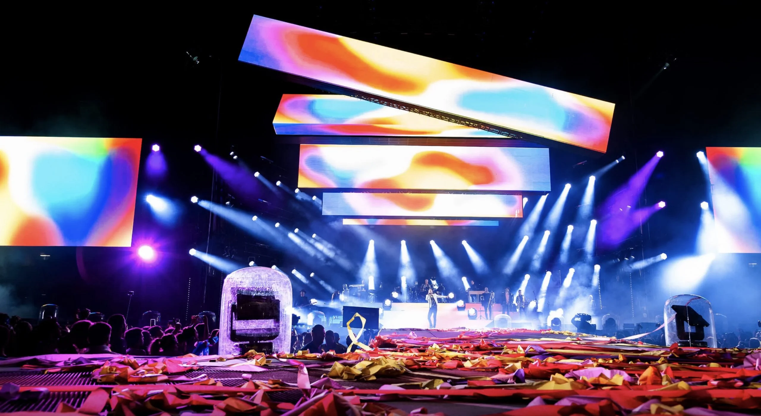 Wide view of the Cremonini stadium stage: angled video bars in vivid colours above beams of light – Cesare Cremonini Stadi 2018, Italy – concert stage design