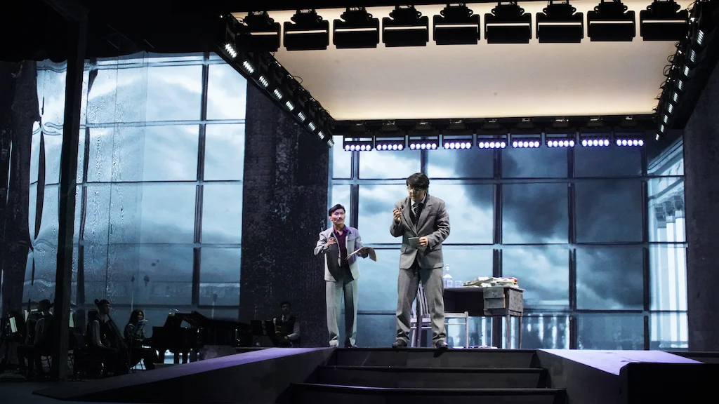 Two performers on stairs in a set framed by tall windows onto a stormy sky, with a light rig above – Waltz Karoly at Turkistan Theatre, Kazakhstan, 2024 – set design