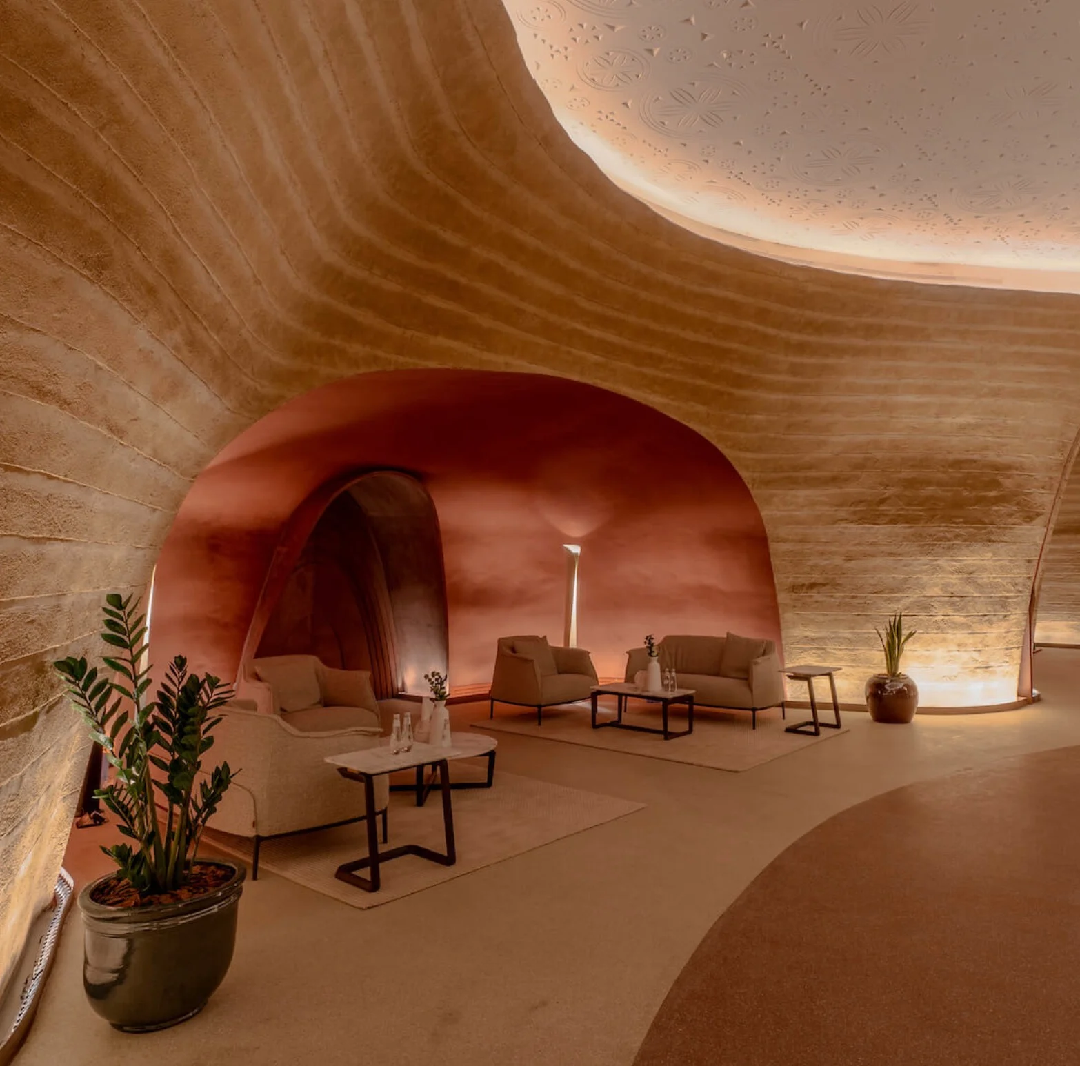 Rammed-earth lounge with armchairs and low tables under a terracotta arch in the cultural center – King Fahad Chair for Poltrona Frau, Riyadh, Saudi Arabia, 2024 – product design