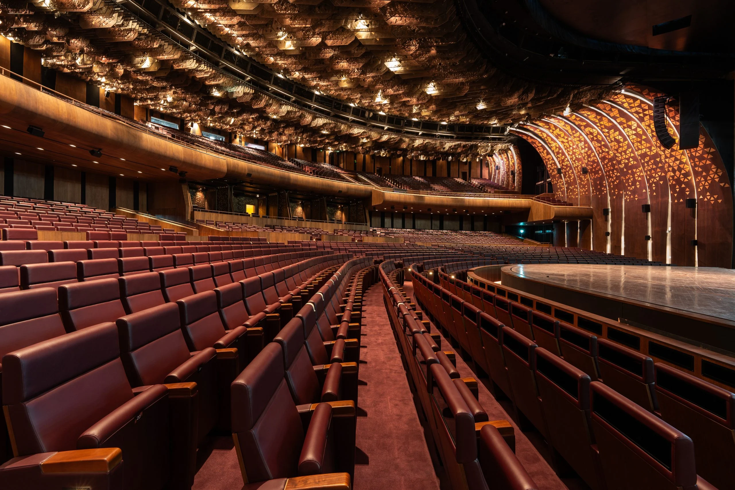 Curving rows of red leather King Fahad chairs with wooden armrests in the main auditorium – King Fahad Chair for Poltrona Frau, Riyadh, Saudi Arabia, 2024 – product design