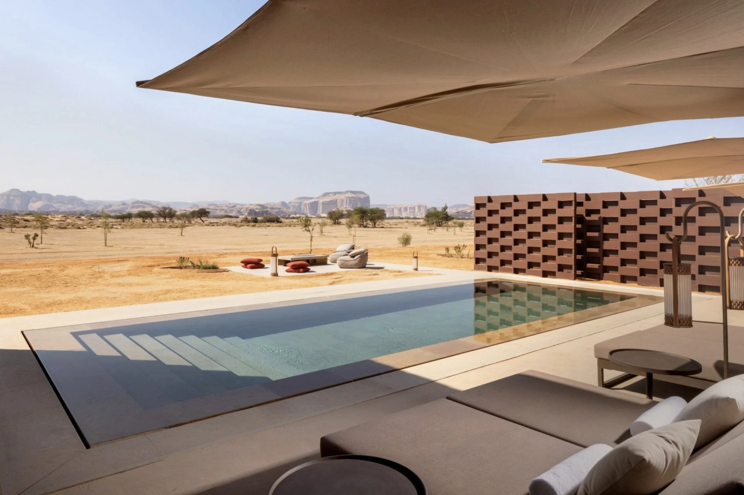 Private pool on a terrace with sun loungers under fabric canopies, overlooking the desert plain – The Chedi Hegra, AlUla, Saudi Arabia, 2024 – hotel architecture