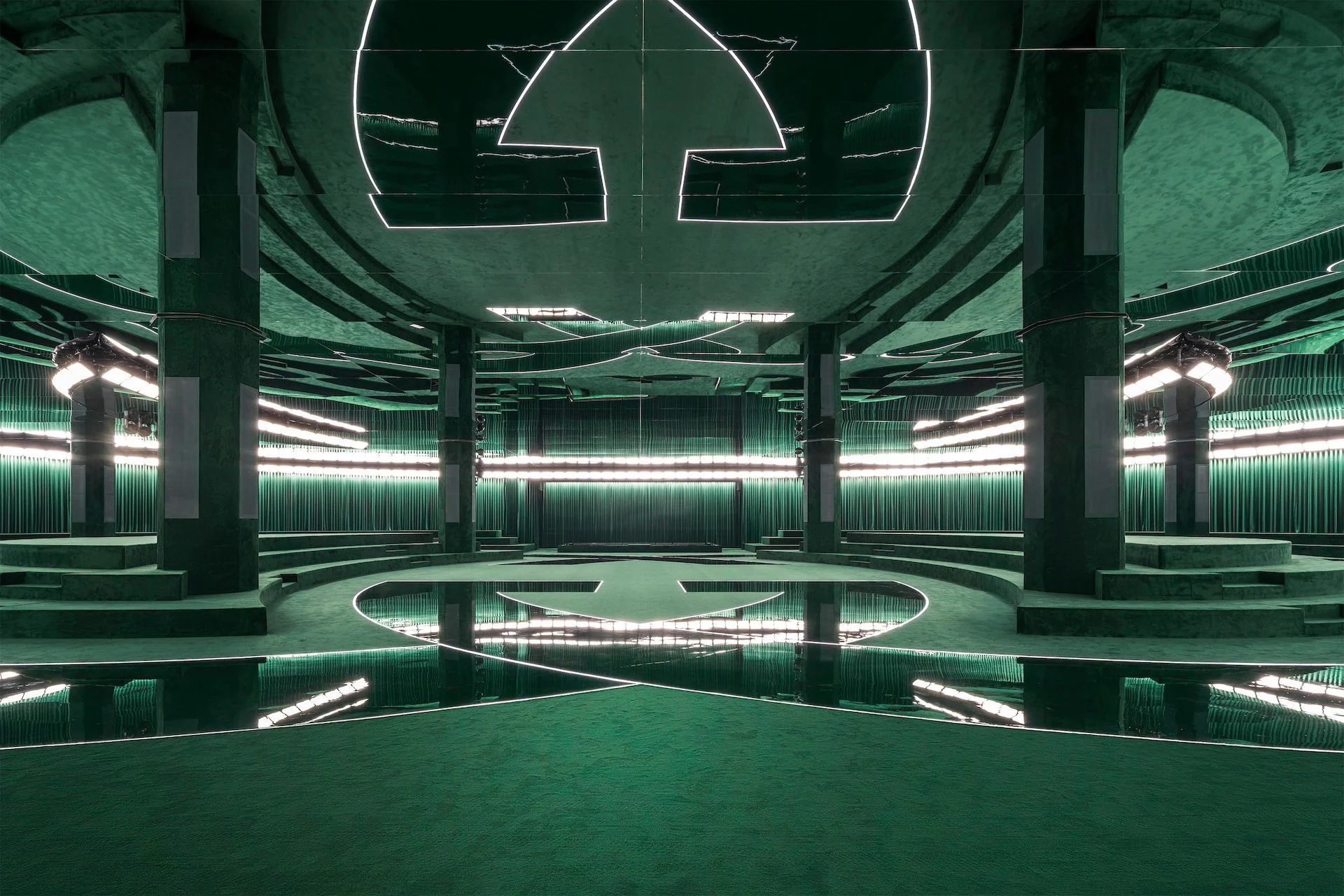 Gucci F/W 2025 show space: green velvet amphitheatre, mirrored floor and the Interlocking G outlined in light – Gucci Fall/Winter 2025, Milan, Italy – fashion show set design