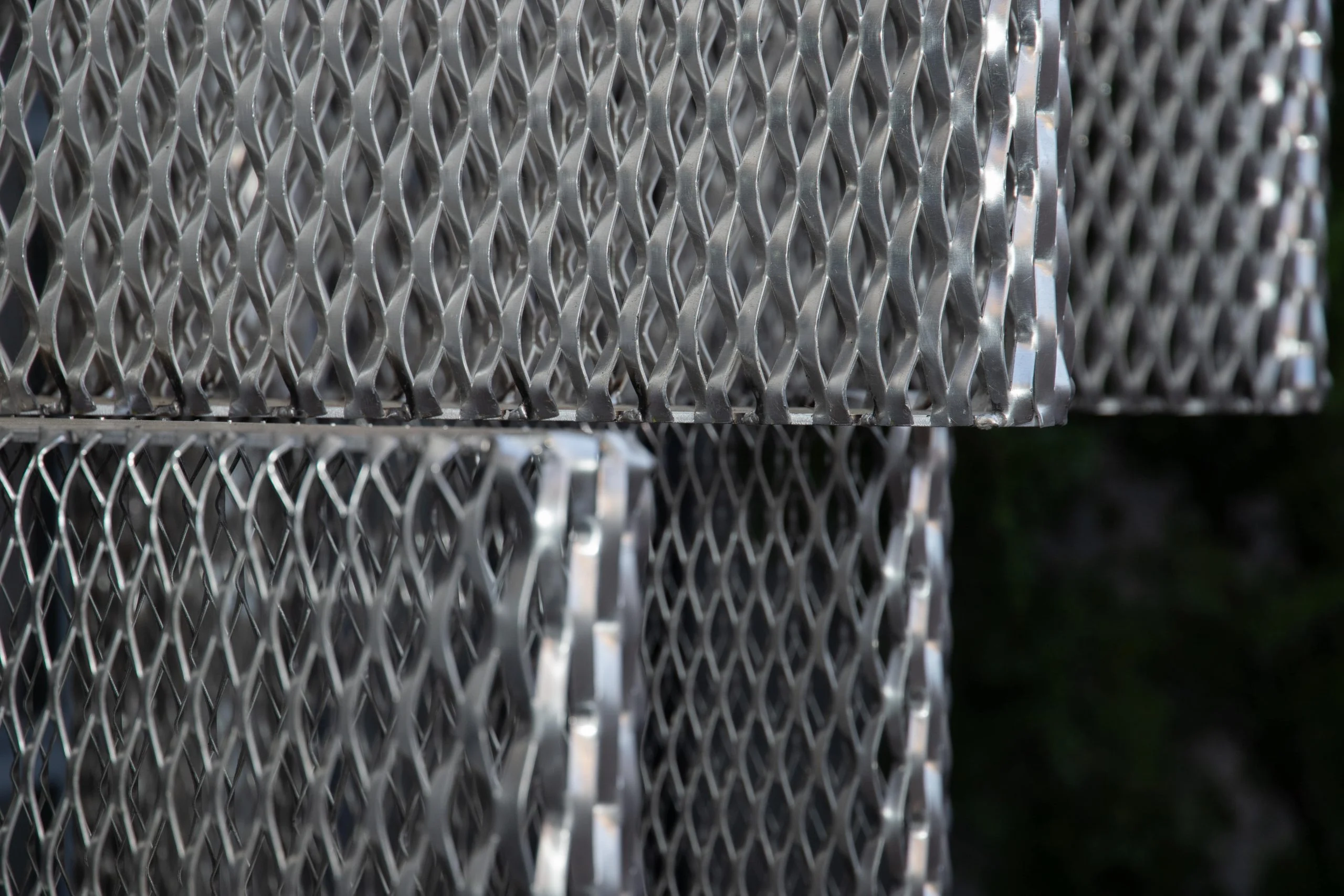 Detail of stacked silver expanded metal mesh modules against dark foliage – Everything Is a Party at Fuorisalone, Milan, Italy, 2025 – event design