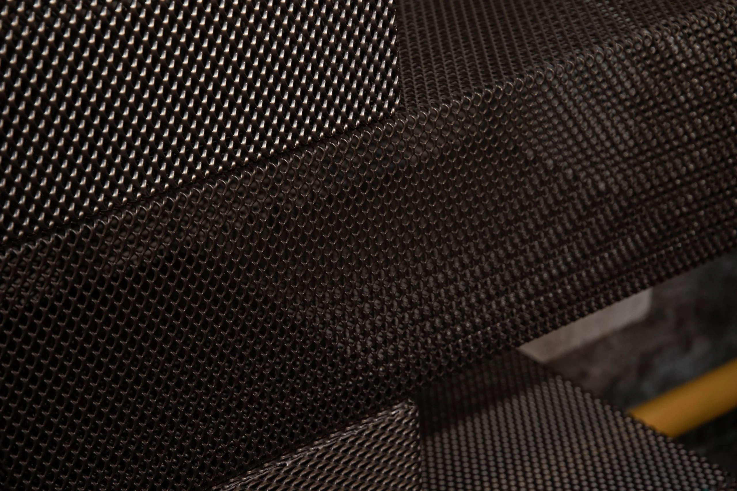 Close-up of dark textured metal mesh surfaces overlapping at an angle – Everything Is a Party at Fuorisalone, Milan, Italy, 2025 – event design