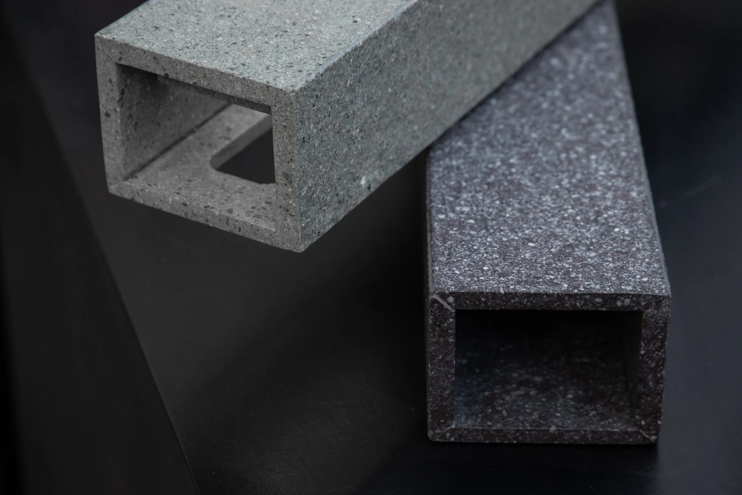 Close-up of two hollow square porphyry profiles in light grey and dark speckled stone – Everything Is a Party at Fuorisalone, Milan, Italy, 2025 – event design
