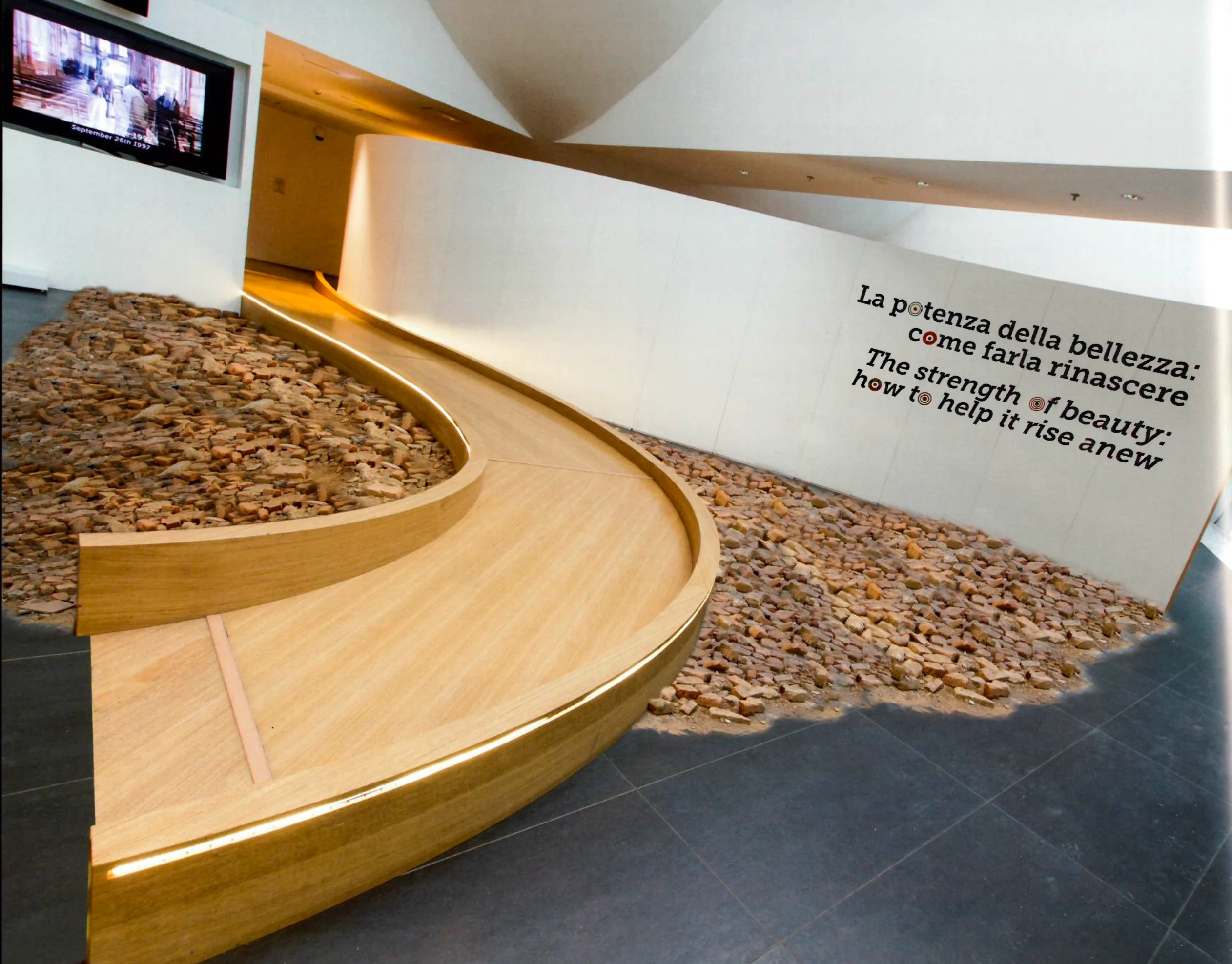 Curving wooden walkway over a bed of rubble, with the bilingual text The strength of beauty on the wall – Italian Pavilion at Expo 2015, Milan, Italy – exhibition design