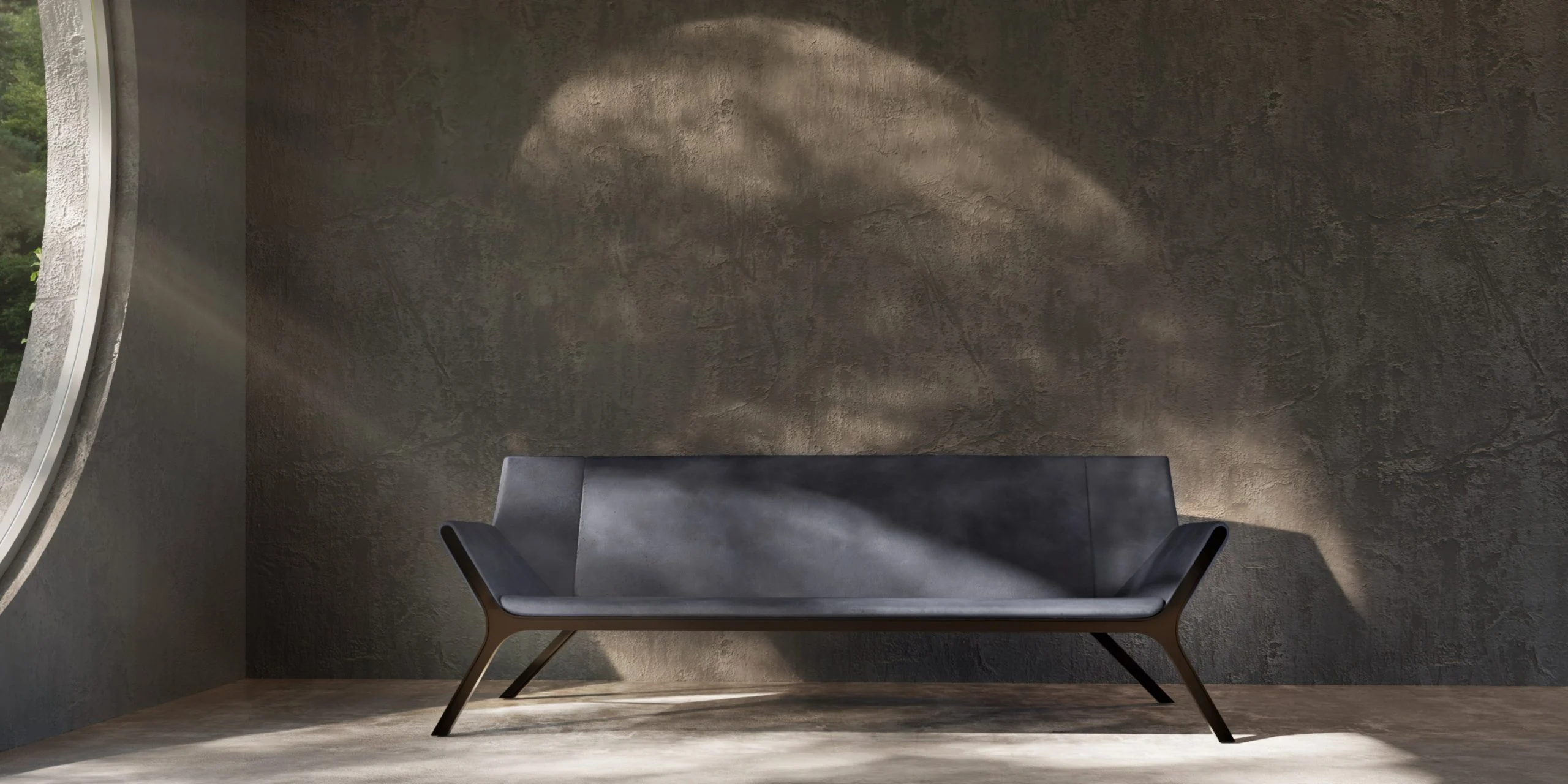 Dark upholstered sofa with angled metal legs in a raw concrete room lit by a round window – Tonino Lamborghini FRAME Collection, Milan, Italy, 2025 – product design