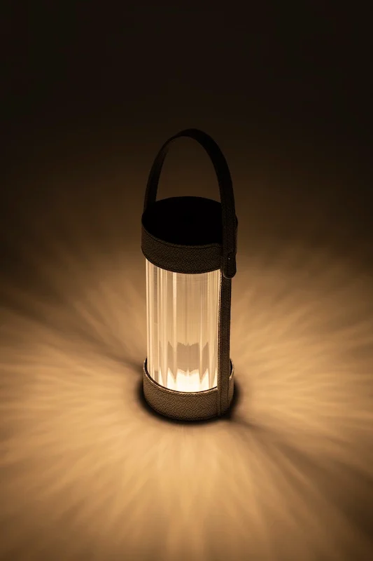 Lit lantern casting a radiating pattern of warm light on the floor in the dark – AlUla Lantern for Artemide, Milan, Italy, 2025 – lighting design
