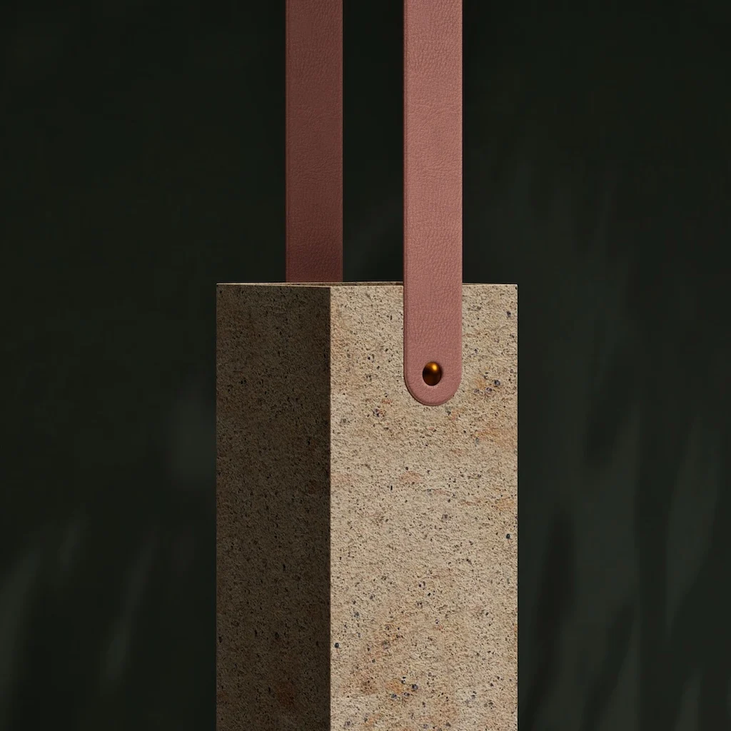 Close-up of a stone pendant with pink leather straps fixed by a metal rivet – Porfido Pedretti Porphyry Furniture, Milan, Italy, 2025 – product design