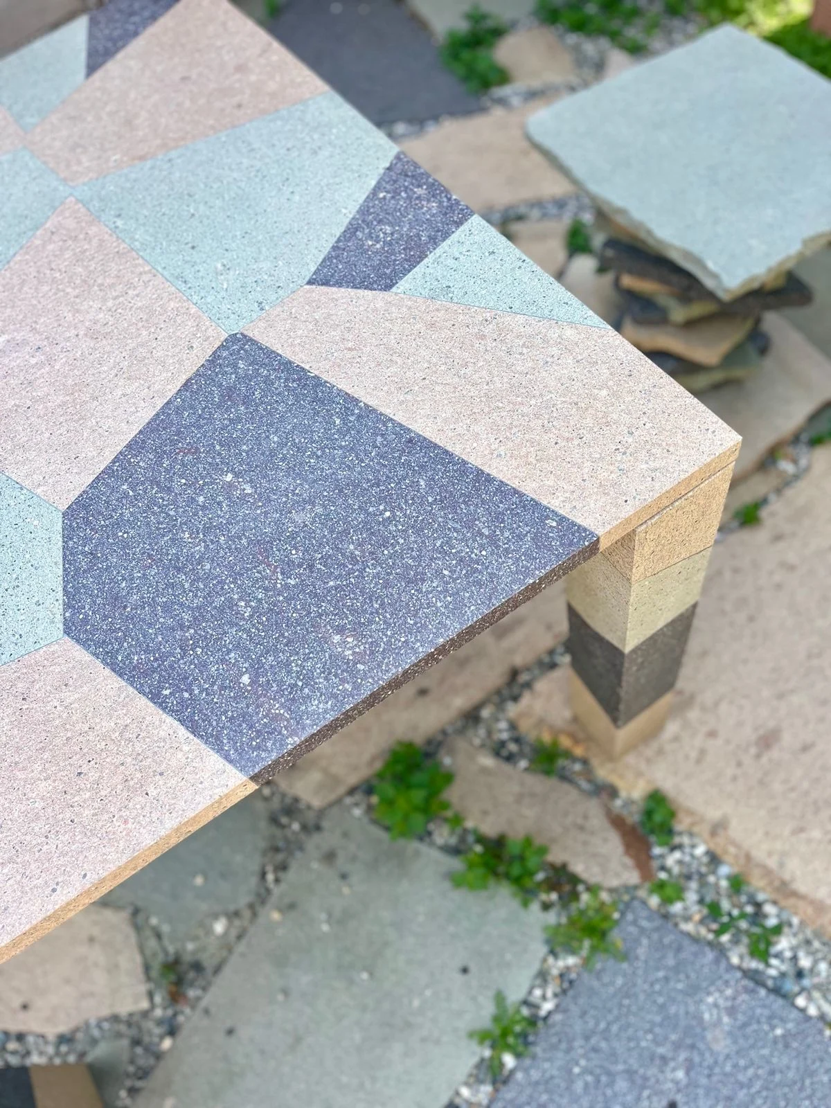 Corner of a table with an inlaid top of pink, green and dark porphyry and a striped leg – Frammenti Collection for Porfido Pedretti, Milan, Italy, 2025 – product design