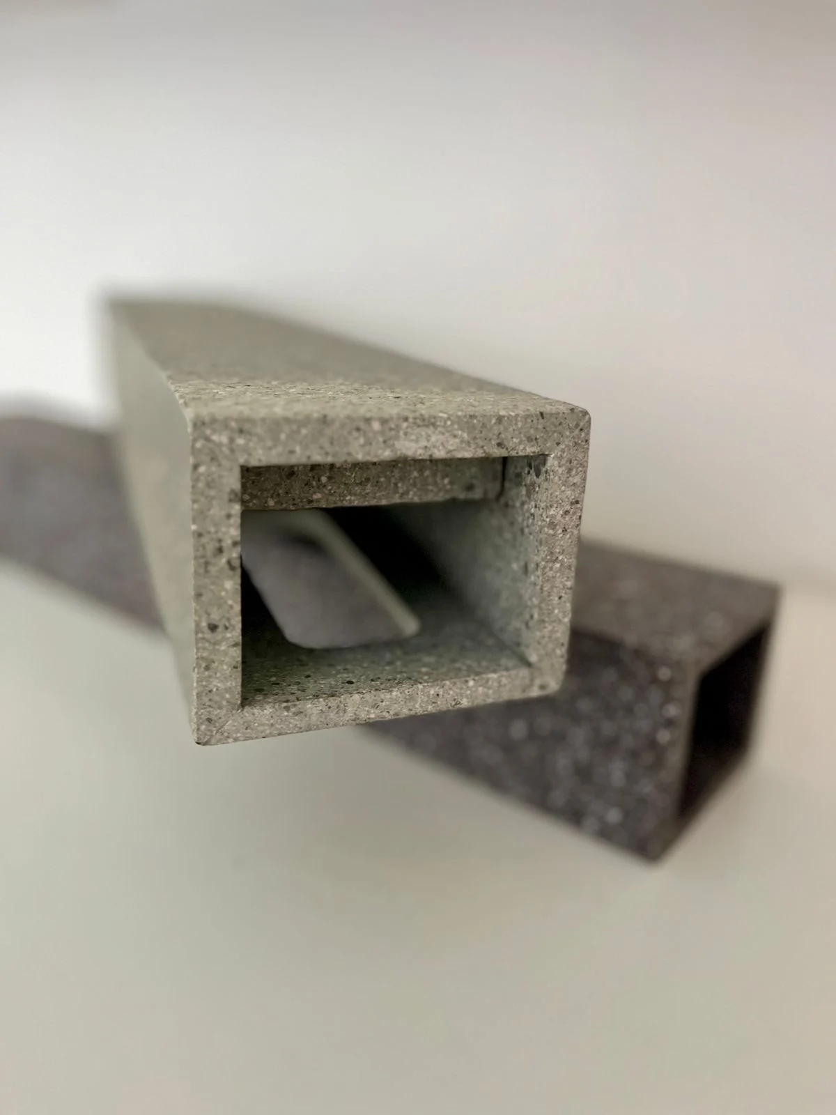 Two hollow square porphyry profiles in grey and dark stone, end view – Frammenti Collection for Porfido Pedretti, Milan, Italy, 2025 – product design
