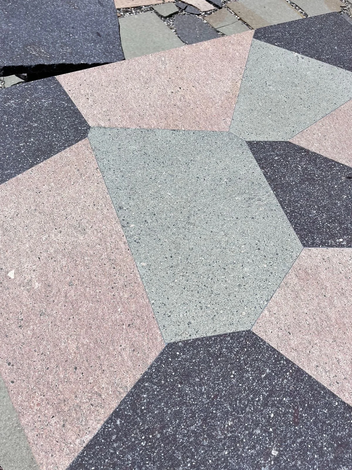 Detail of a geometric pattern of pink, green and dark grey porphyry pieces – Frammenti Collection for Porfido Pedretti, Milan, Italy, 2025 – product design
