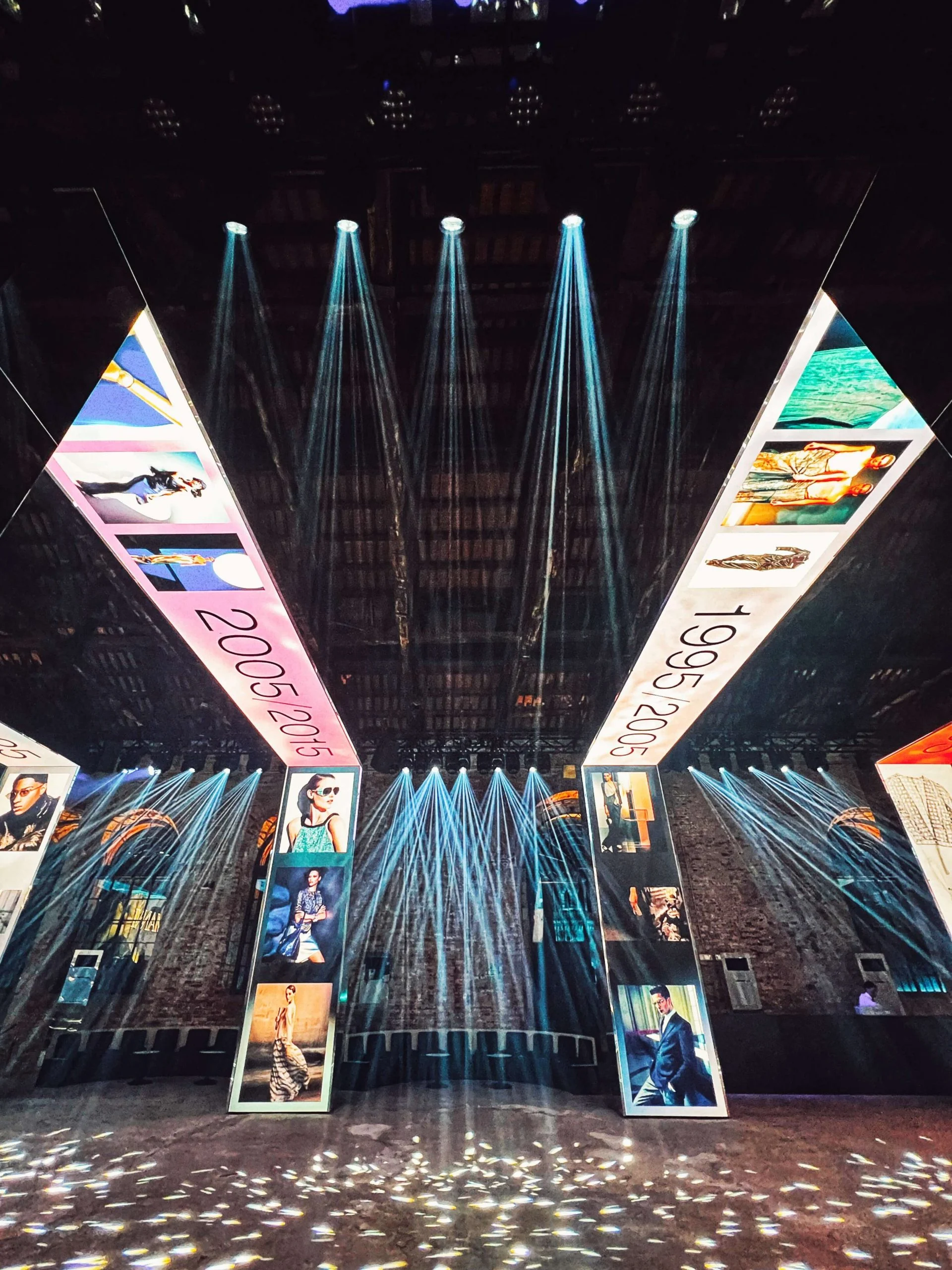 Two LED portal sides with fashion images and dates, blue spotlight beams fanning against the brick wall – Armani/Archivio Party at Venice Film Festival, Italy, 2025 – event design
