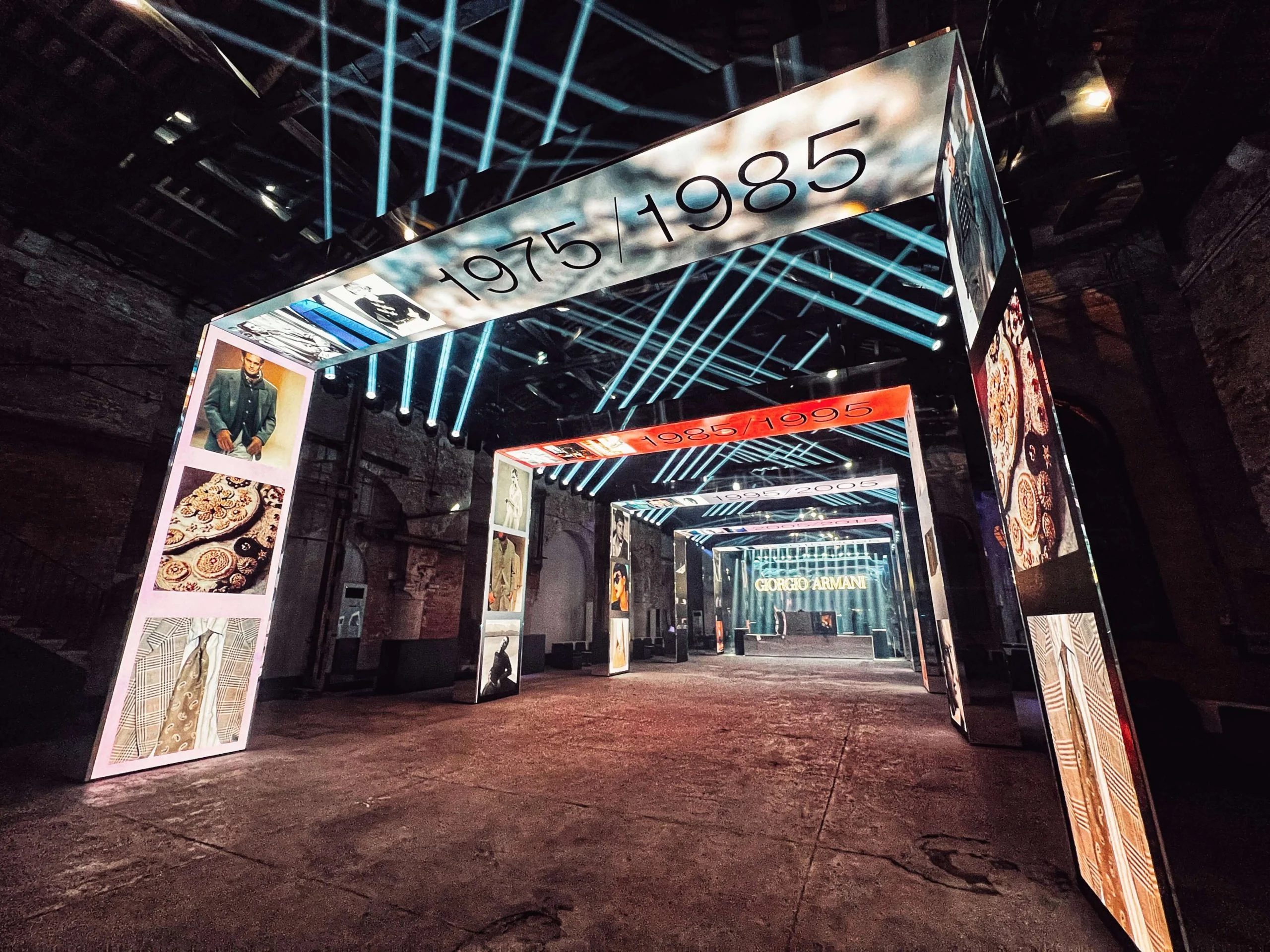 LED portal marked 1975/1985 opening onto a sequence of decade portals, blue light bars overhead – Armani/Archivio Party at Venice Film Festival, Italy, 2025 – event design