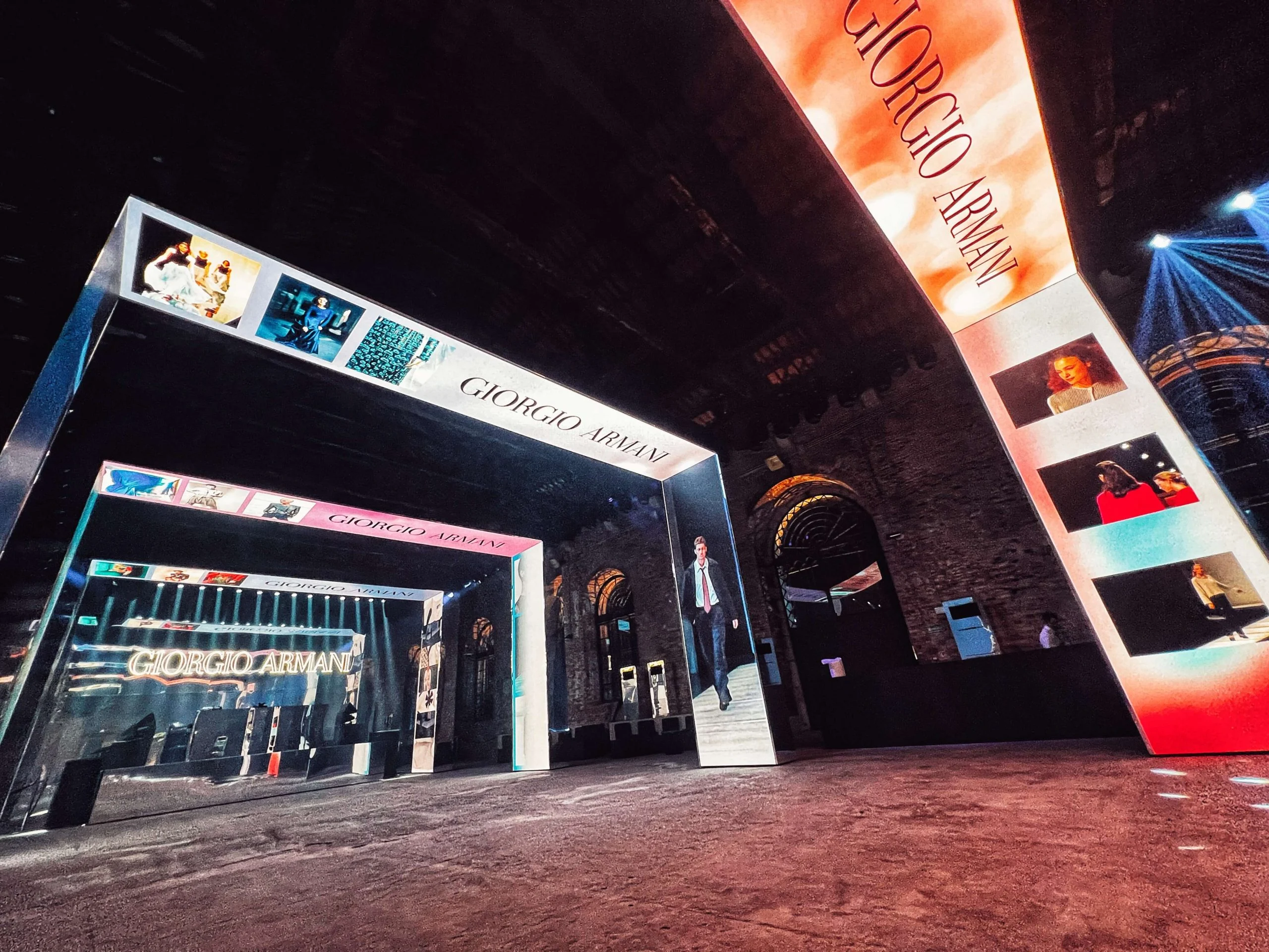 Wide-angle view of the portal corridor entrance, with a giant red LED panel bearing the Giorgio Armani name – Armani/Archivio Party at Venice Film Festival, Italy, 2025 – event design