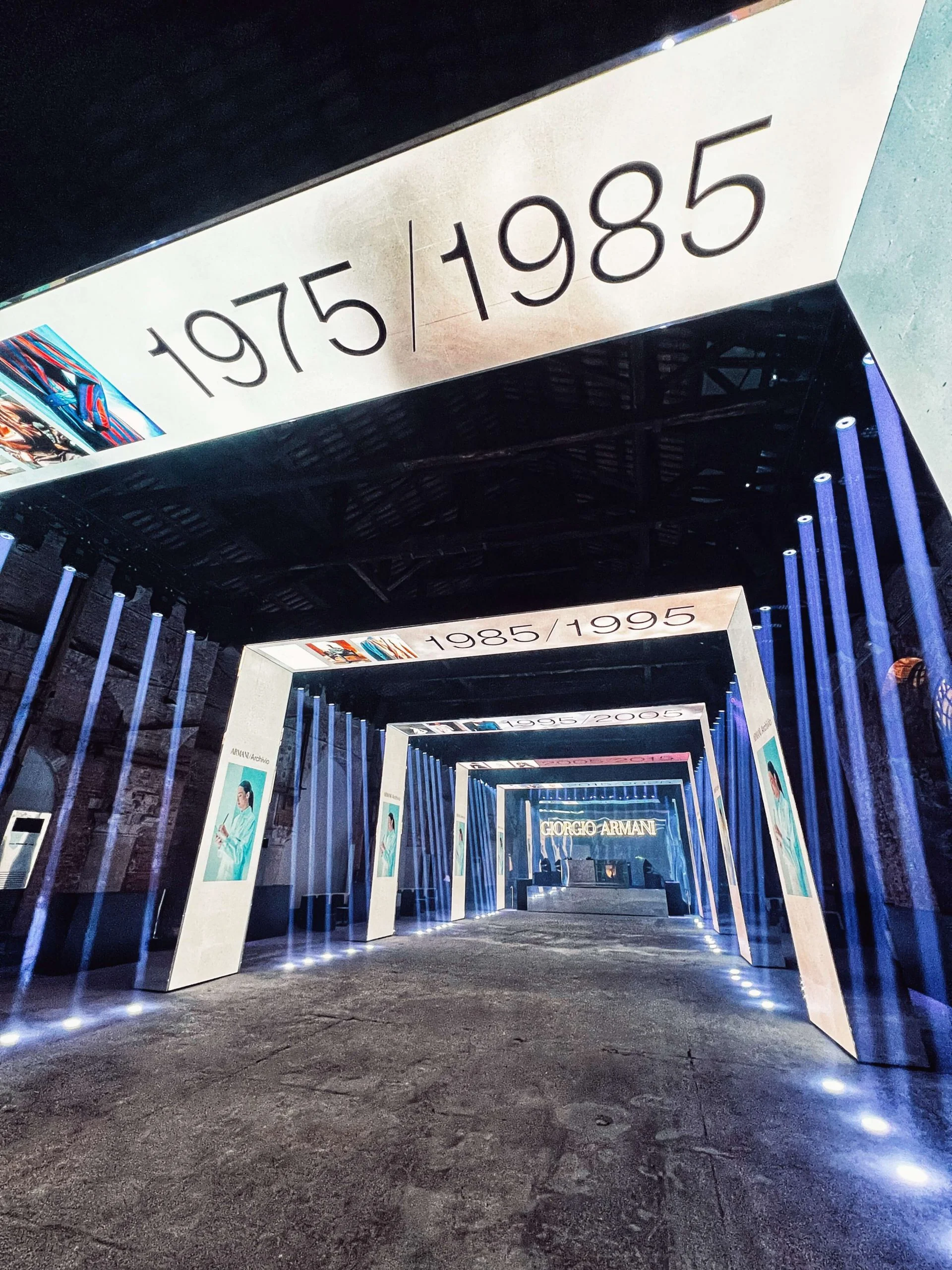 Upward view through the 1975/1985 portal along the corridor lined with vertical blue light tubes – Armani/Archivio Party at Venice Film Festival, Italy, 2025 – event design