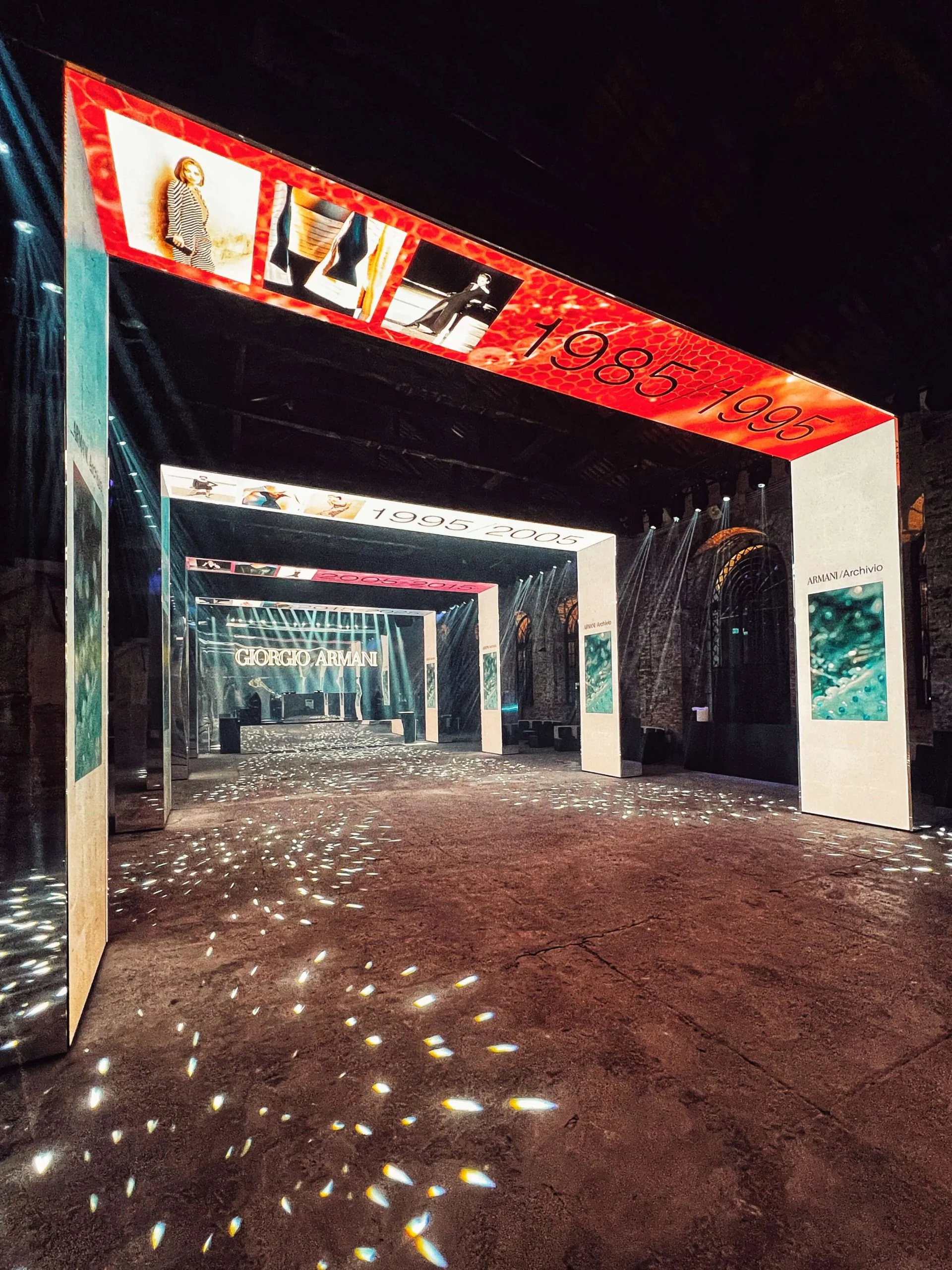 Red 1985/1995 portal leading to further decade portals, with sparkling light dots on the floor – Armani/Archivio Party at Venice Film Festival, Italy, 2025 – event design