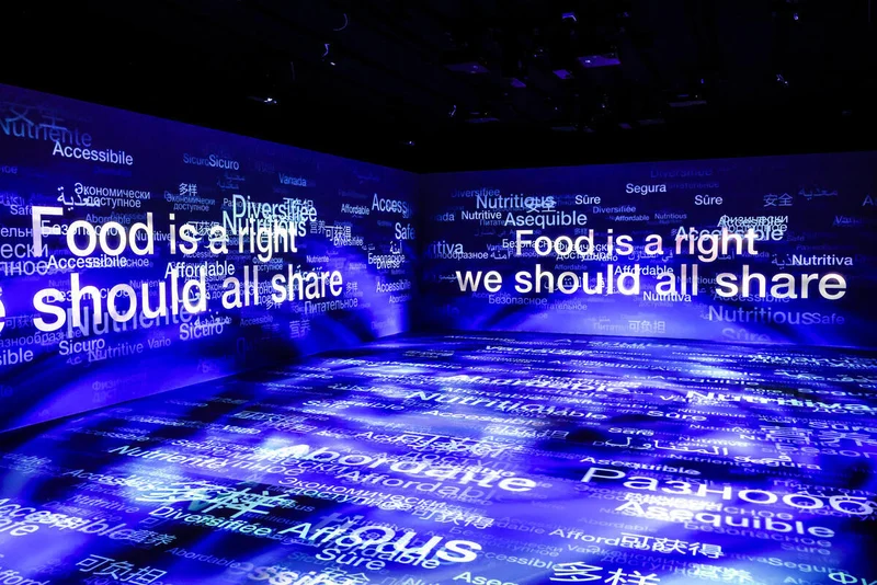 Dark room with Food is a right we should all share and words in many languages projected on walls and floor – FAO MuNe Food and Agriculture Museum, Rome, Italy, 2025 – exhibition design