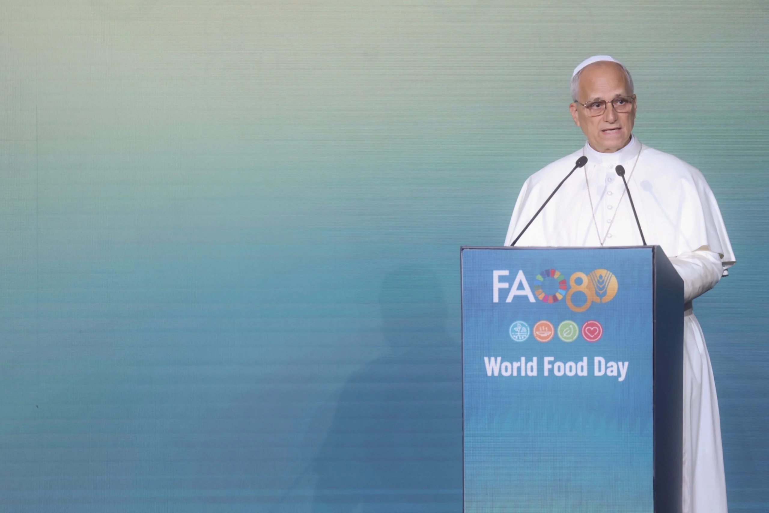 Speaker in white robes at a FAO80 World Food Day podium against a teal backdrop – FAO MuNe Food and Agriculture Museum, Rome, Italy, 2025 – exhibition design