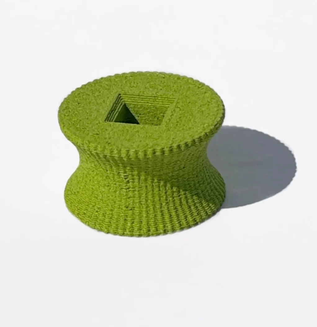 Green 3D-printed textured spool with a square opening on a white background – Deep Surfaces at Palazzo Zorzi, Venice, Italy, 2025 – exhibition design
