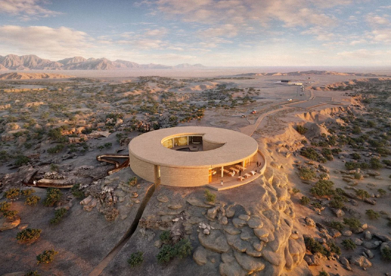 Aerial render of the ring-shaped building around a central courtyard, set on a rock spur in the desert valley – Ayn Dawkah Visitor Centre and Manufacture, Wadi Dawkah, Oman, 2025 – architecture, under construction