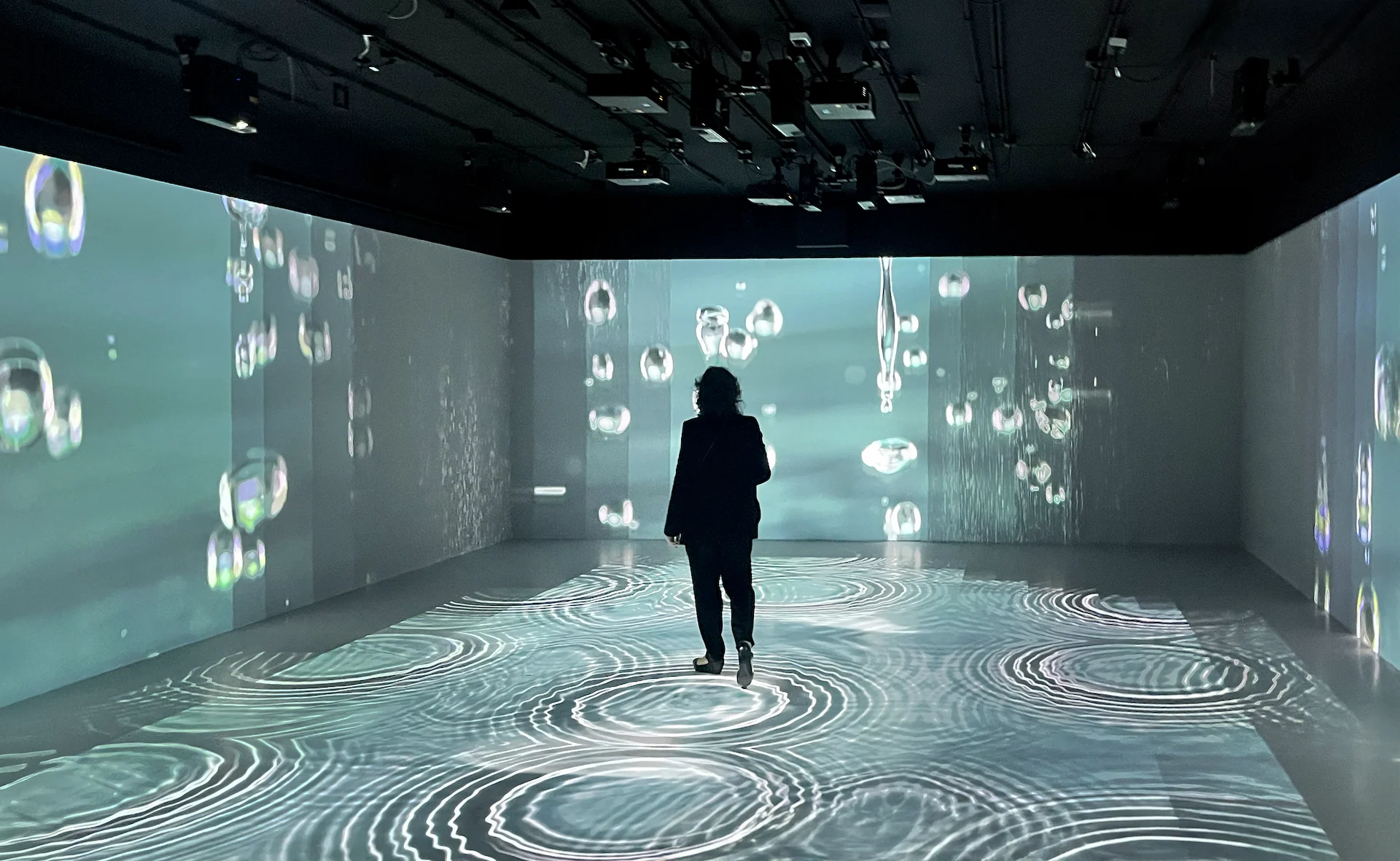 Visitor walking through an immersive room with water drops projected on the walls and ripples on the floor – FAO MuNe Food and Agriculture Museum, Rome, Italy, 2025 – exhibition design