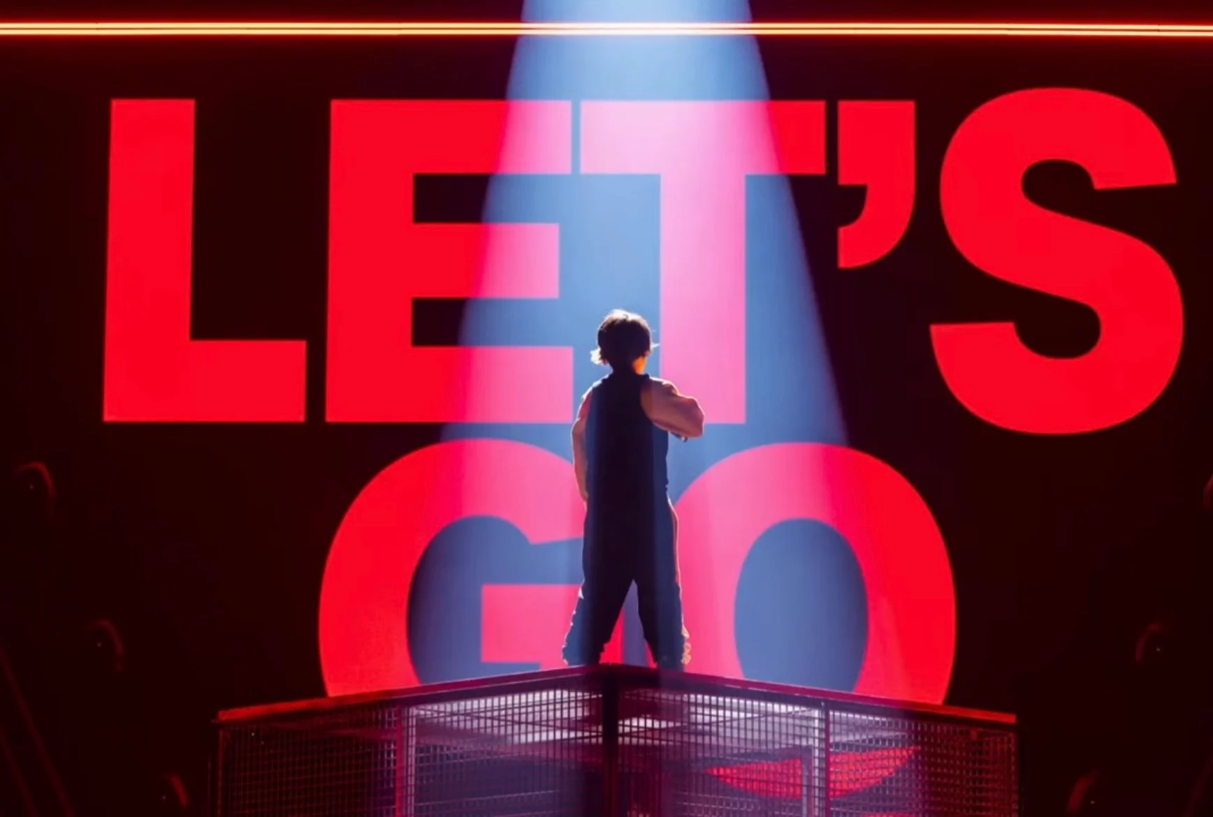 Singer seen from behind on the platform, facing giant red LED letters reading LET'S GO – Leonardo Giovannangeli at Junior Eurovision 2025, Tbilisi, Georgia – concert stage design