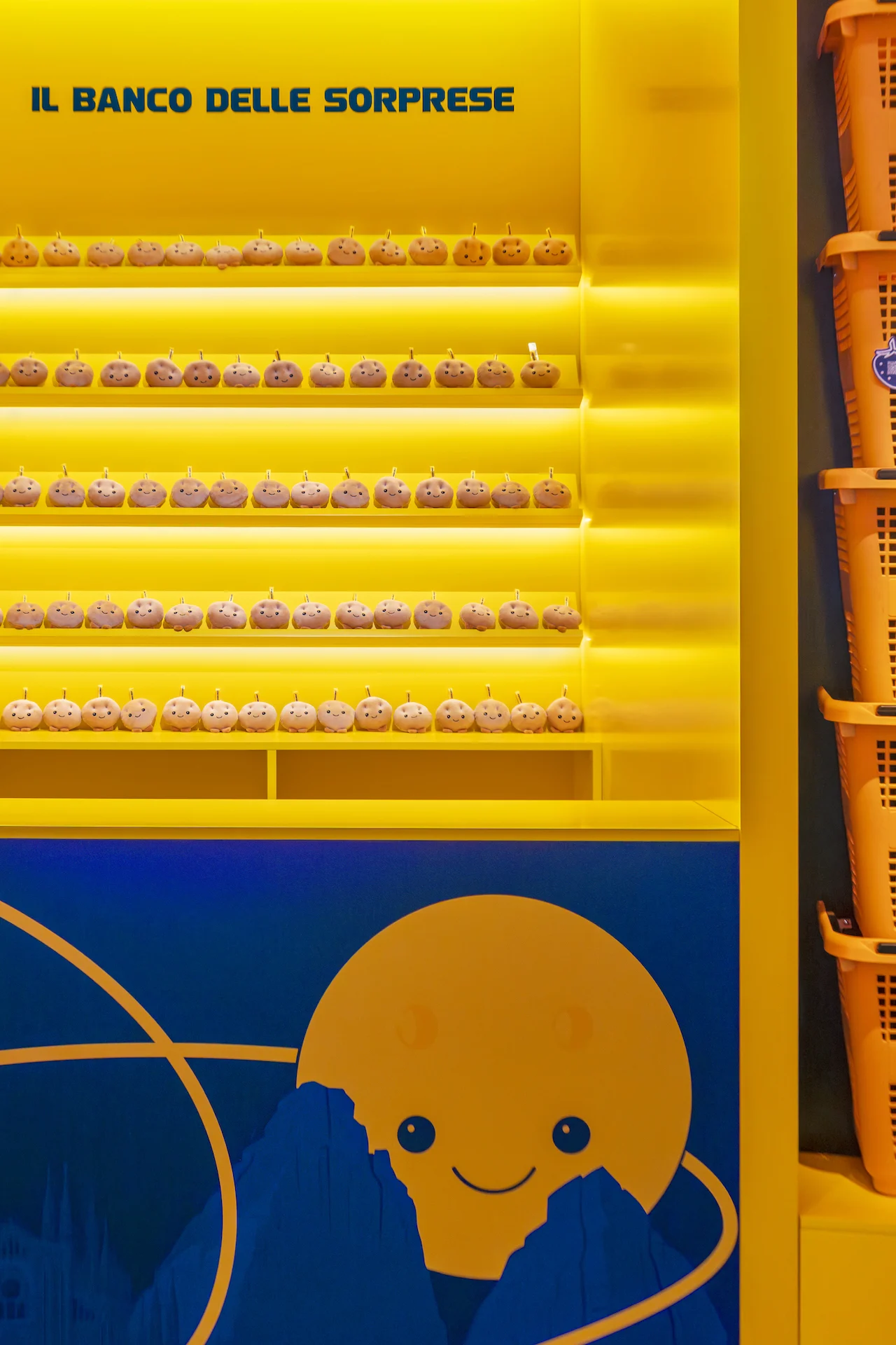 Il Banco delle Sorprese: glowing yellow shelves of small treats above a smiling cartoon moon – Casa Esselunga at Milano Cortina 2026, Italy – exhibition design