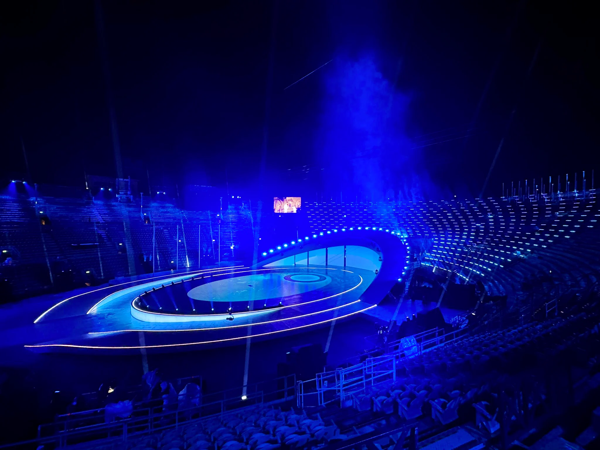 Empty Arena di Verona in blue light, with the oval stage and its LED-outlined rings – Milano Cortina 2026 Olympic Closing Ceremony, Verona, Italy – stage design