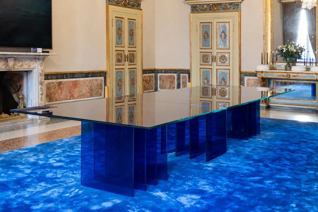 STRACTA table at eye level, its glass top reflecting painted doors, with a marble fireplace beside it – STRACTA Table for Driade, Milan, Italy, 2026 – product design
