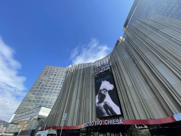 Pleated metal façade of the Teatro Nazionale Ivo Chiesa with a large vertical screen against blue sky – Teatro Nazionale Ivo Chiesa Façade, Genoa, Italy, 2025 – architectural refurbishment