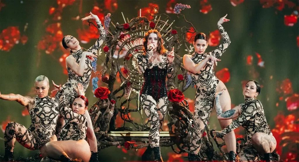 Angelina Mango on a throne of branches and red roses, surrounded by dancers in black lace bodysuits – Angelina Mango at Eurovision 2024, Malmö, Sweden – concert stage design
