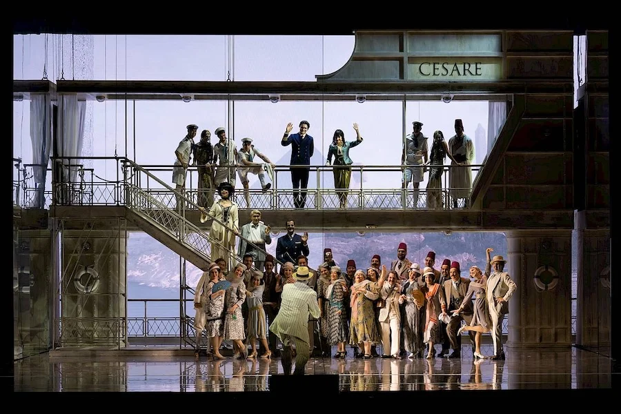 Chorus and soloists on a two-level ship-like set with a staircase and CESARE lettering above – Giulio Cesare in Egitto at Opéra de Monte-Carlo, Monte Carlo, Monaco, 2025 – set design
