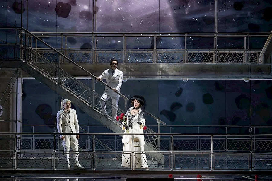 Three singers in white on the stairs and deck of the set against a starry projected sky – Giulio Cesare in Egitto at Opéra de Monte-Carlo, Monte Carlo, Monaco, 2025 – set design