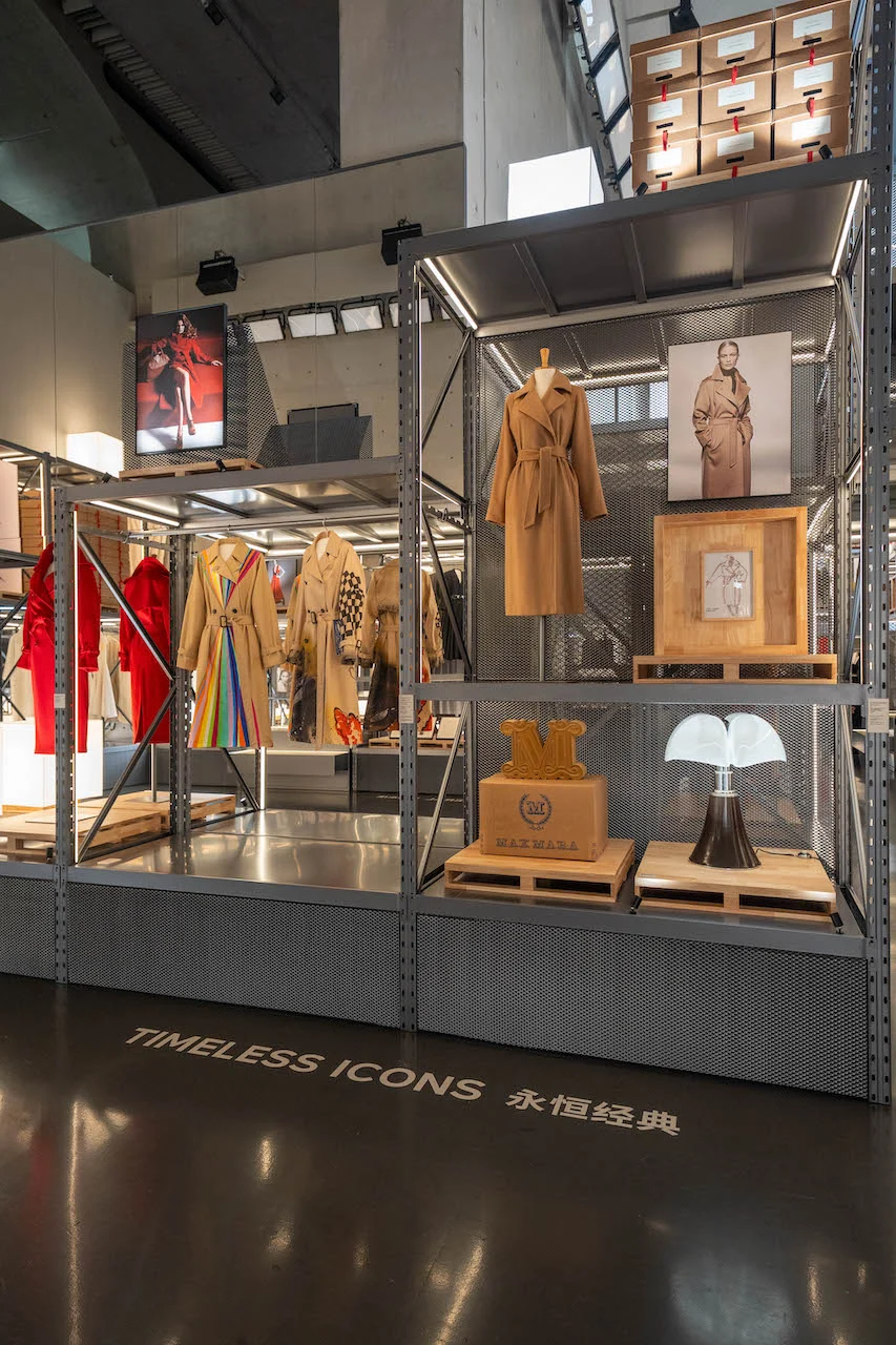 Metal storage shelving with Max Mara camel coats, a lamp and wooden crates above the floor text Timeless Icons – Max Mara The Max! at Long Museum, Shanghai, China, 2026 – exhibition design
