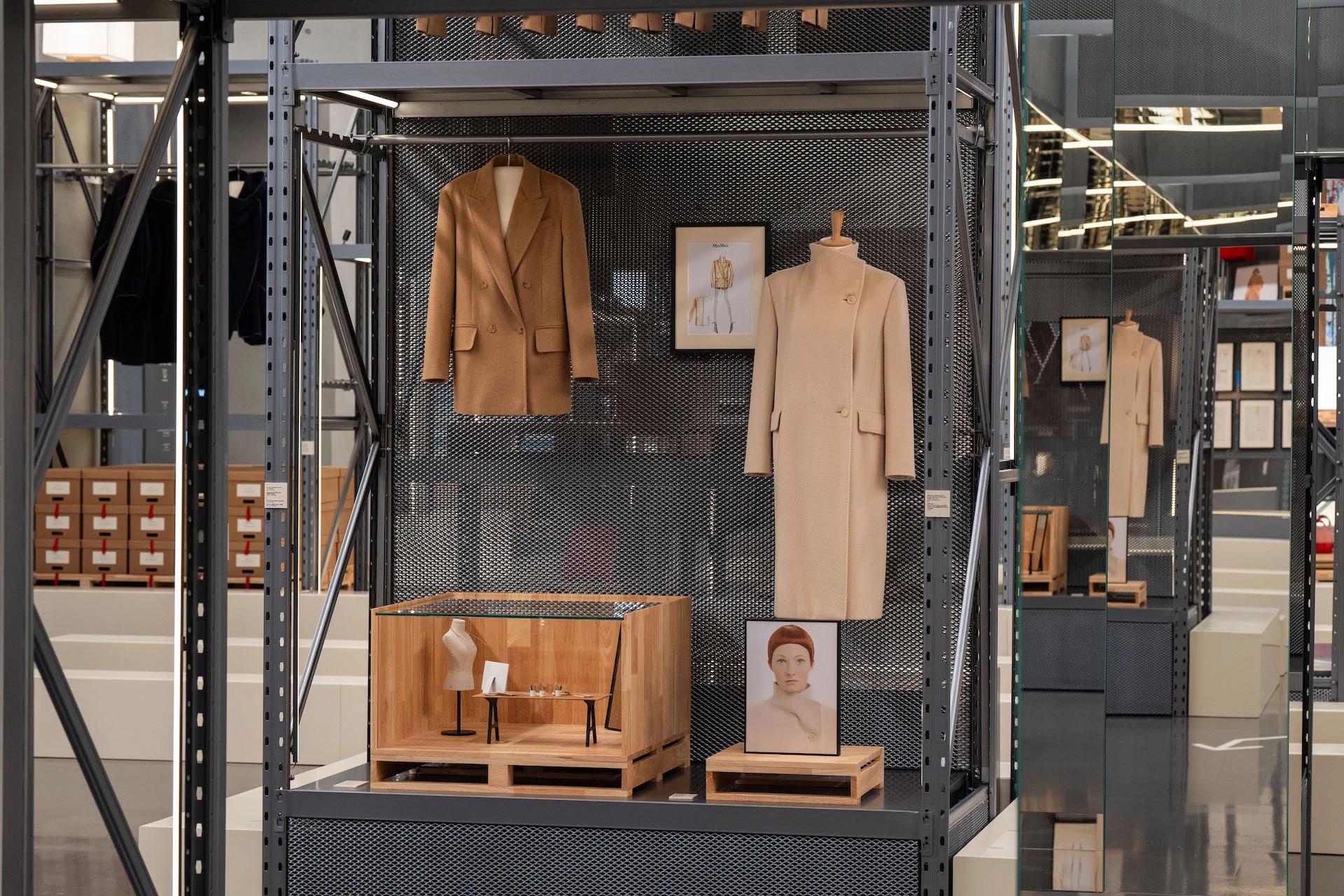 Two camel coats and a framed sketch on perforated metal shelving, with a small wooden display case below – Max Mara The Max! at Long Museum, Shanghai, China, 2026 – exhibition design