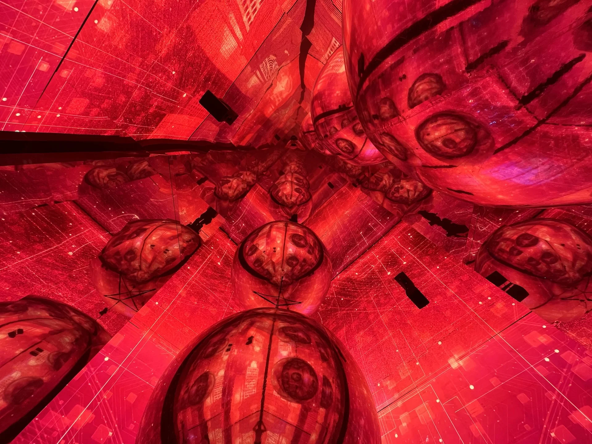 Mirrored ceiling reflecting red-lit spheres and LED screens, creating an infinite kaleidoscopic effect – Mastercard Innovation Forum 2023, Milan, Italy – event design